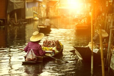 Thai meyve satıcısı Tayland 'da yüzen pazarda ahşap tekne kullanıyor. 