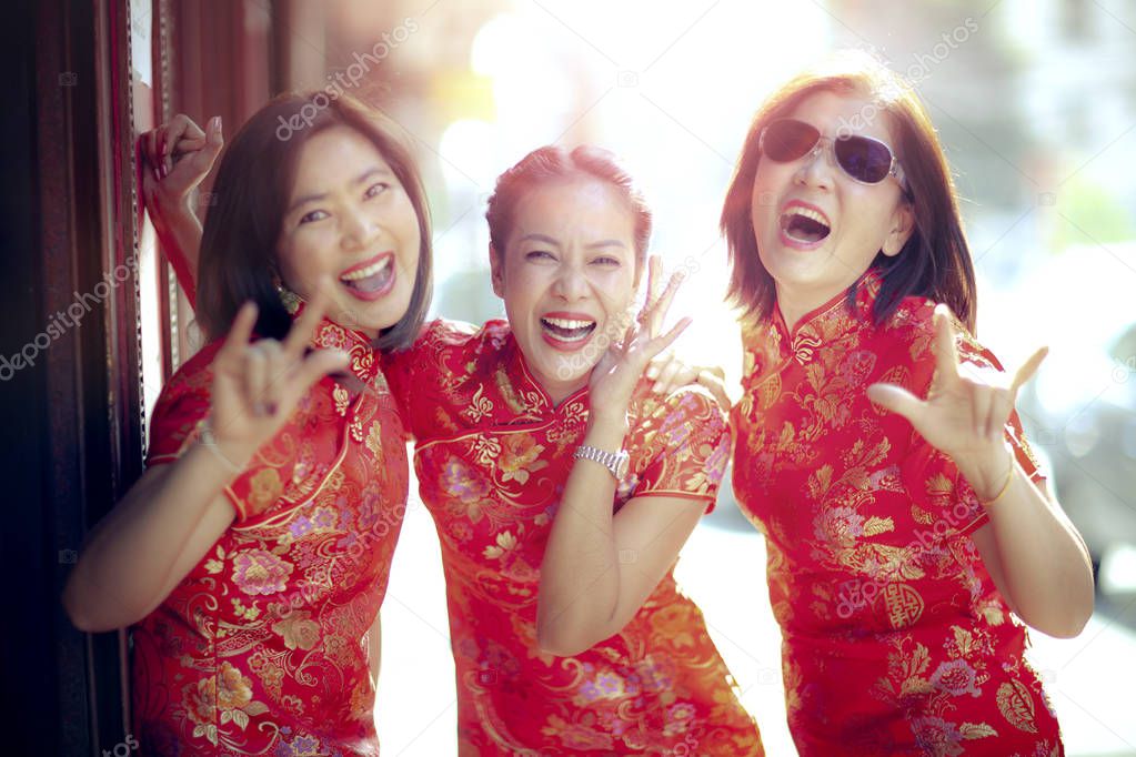 group of asian woman wearing chinese tradition clothes toothy smiling face happiness emotion and hand sign i love you 