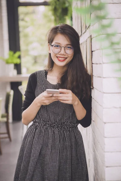 美丽的亚洲年轻女子牙齿笑脸幸福情绪与智能手机在手 — 图库照片