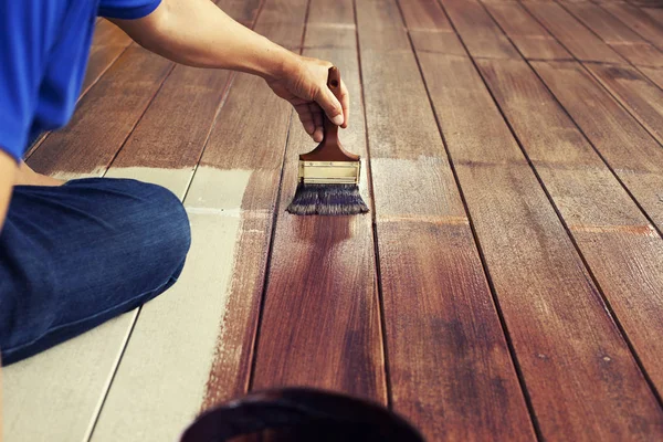 Hand och målningen borste måla brun färg på trä golv, diy con — Stockfoto