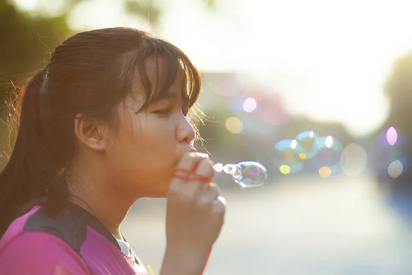 Asiatische Teenager entspannen mit Suppenblase gegen schöne Sonne l — Stockfoto