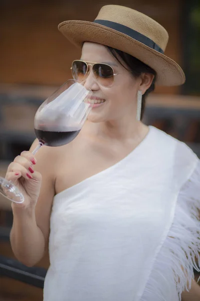 beautiful asian woman drinking red wine in wine glass