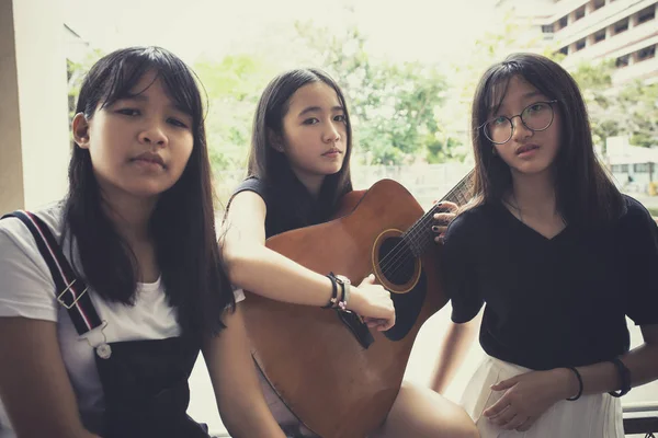 Tres asiático adolescente con español guitarra pose como un música marca —  Fotos de Stock