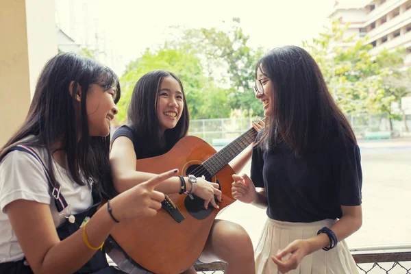 Grupo de asiático adolescente de pé ao ar livre dobrando espanhol guitarra um — Fotografia de Stock