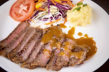 beyaz tabakta yemeye hazır dilimlenmiş biftek