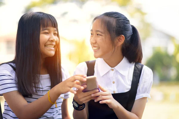 Dois asiático adolescente rindo com felicidade rosto leitura mensagem — Fotografia de Stock