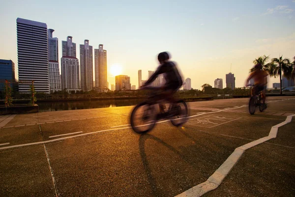 Hombre montar en bicicleta en carril bici en el parque público de la ciudad por la mañana —  Fotos de Stock