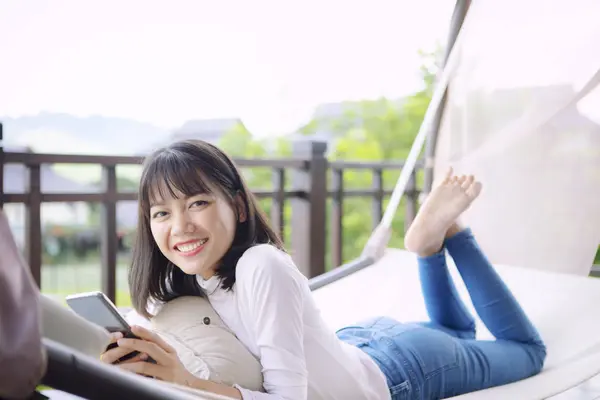 Ásia mais jovem mulher toothy sorrindo com felicidade segurando inteligente — Fotografia de Stock