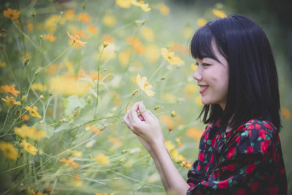 Porträtt av asiatiska yngre kvinna modell pose i gula blomman Bloo — Stockfoto