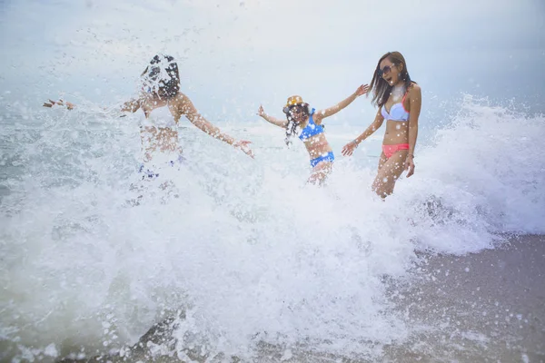 三个女人的幸福情感与飞溅的海滩波浪 — 图库照片