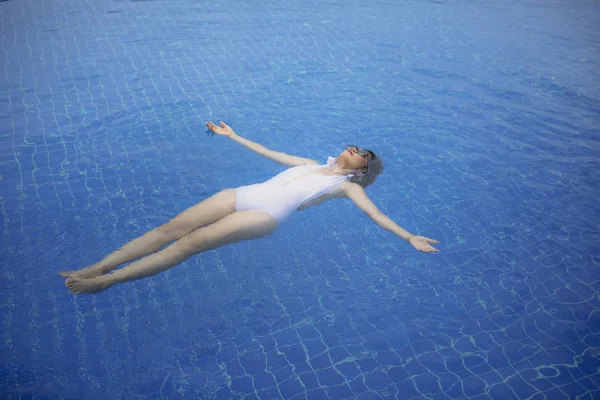 Hermosa mujer más joven relajarse en la piscina de agua azul —  Fotos de Stock