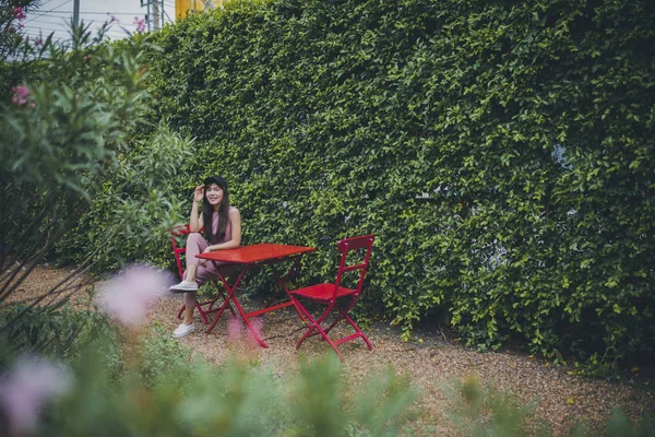 Dente sorrindo rosto de ásia mais jovem mulher sentado no verde parque — Fotografia de Stock