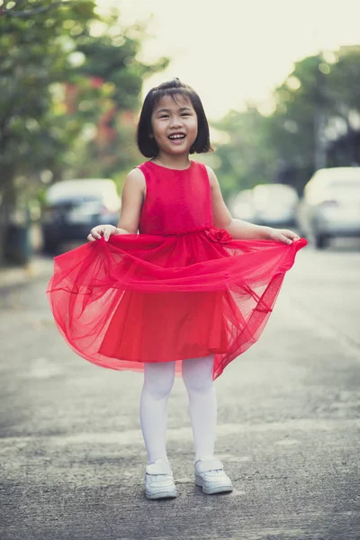 Asina crianças menina vestindo saia vermelha vestido de dente sorridente rosto — Fotografia de Stock