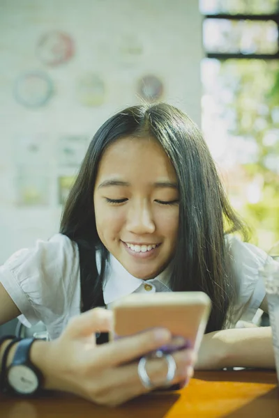 Fata adolescentului asiatic care cauta ecranul smartphone-ului si toothy s — Fotografie, imagine de stoc