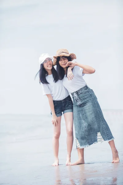 Två glada asiatiska tonåring lycka på havet stranden — Stockfoto