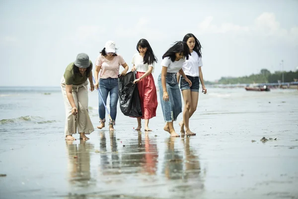 Grupo de voluntarios mantener limpio en la playa del mar —  Fotos de Stock