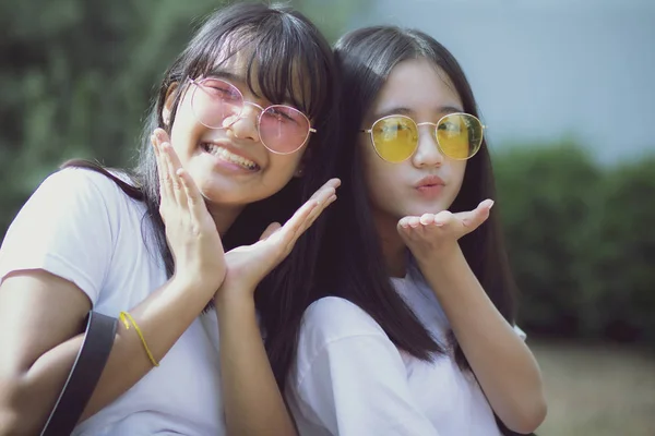Портрет двух азиатских подростков, расслабляющихся со счастьем в зеленом — стоковое фото