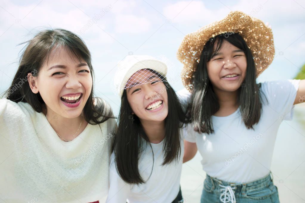 three asian younger woman and teen happiness on sea beach