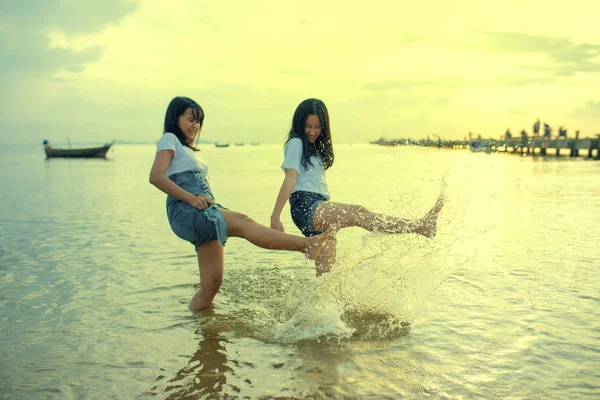 Dos asiático adolescente relajante y jugando ons verano vacaciones mar —  Fotos de Stock