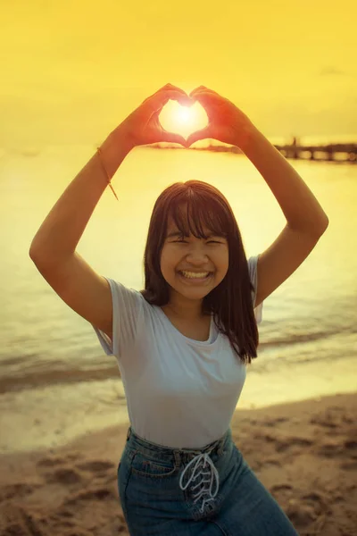 Azji nastolatek znak serca kształt ręcznie z pięknym wschodzie słońca sk — Zdjęcie stockowe