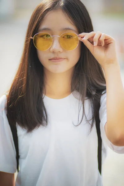Pretty asian teenager wearing eye glasses standing outdoor — Stock Photo, Image