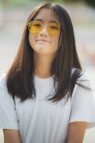 Cheerful asian teenager wearing sun glasses with relaxing outdoo — Stock Photo, Image