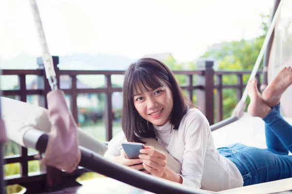 Hermosa Asiático Más Joven Mujer Acostado Con Smartphone Toothy Sonriendo —  Fotos de Stock