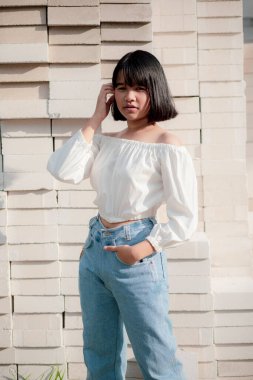 Asyalı ergen, tuğla yığınının üzerinde oturuyor. 