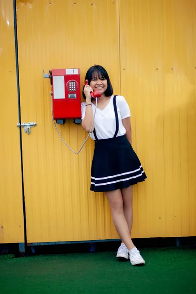 Ásia Adolescente Falando Para Idade Modelo Público Telefone Contra Amarelo — Fotografia de Stock