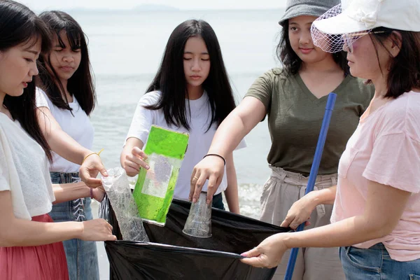 一组志愿者把海滩上的塑料垃圾清理干净 — 图库照片