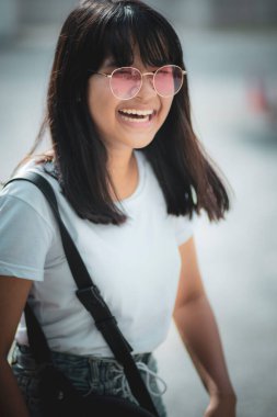 Asyalı bir gencin açık havada duran mutlu yüzü