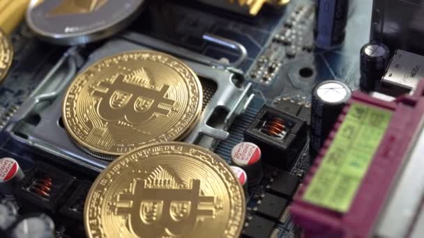 Moedas de ouro bitcoin BTC e criptomoeda Ethereum na placa de processador de computador eletrônico. Conceito de mineração criptomoeda — Vídeo de Stock