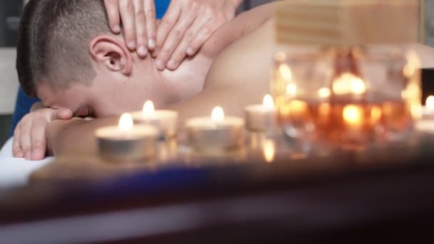 O massagista que faz massagem de saúde de pescoço e cabeça de homem no salão de spa. 4K — Vídeo de Stock