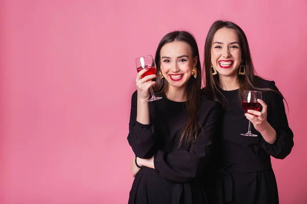 Dos hermosas niñas gemelas celebran con éxito la finalización del proyecto y beber vino . —  Fotos de Stock