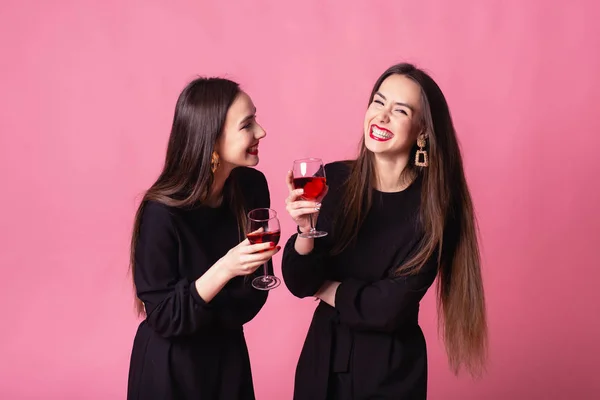 Dwie piękne bliźniaczki świętują firmową imprezę sylwestrową, piją wino i rozmawiają — Zdjęcie stockowe