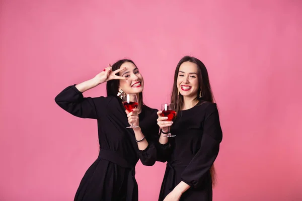 Dwie piękne bliźniaczki świętują firmową imprezę sylwestrową, piją wino i rozmawiają — Zdjęcie stockowe