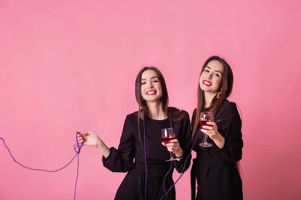 Two women celebrate the New Year party having fun laughing and drinking wine. — Stock Photo, Image