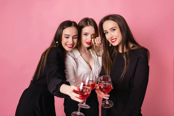 三个女人在庆祝母鸡聚会时开开怀大笑 穿着黑白相间的晚礼服 穿着粉红相间的背景 欢快的情绪 明亮的妆容 室内派对的女孩子们摆出一副笑脸 — 图库照片