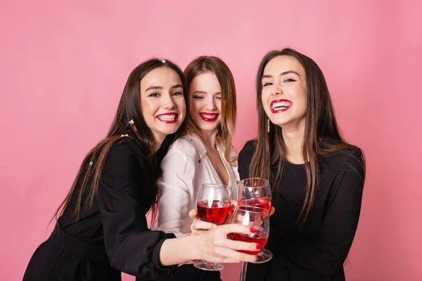 Tres mujeres celebran la fiesta de Año Nuevo divirtiéndose riendo bajo el confeti volador y bebiendo vino . —  Fotos de Stock