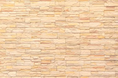 sarı dekoratif taş duvar yüzeyinin arkaplanı ve dokusu. Modern stil dekoratif düzensiz taş çatlamış duvar dokusu yüzeyi çimentoyla.