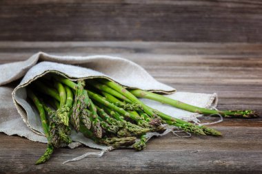Kuşkonmaz yeşil bir ahşap arka plan üzerinde taze.
