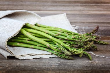 Kuşkonmaz yeşil bir ahşap arka plan üzerinde taze.