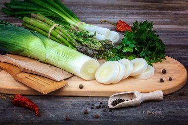 Kuşkonmaz, soğan ve maydanoz, taze bir ahşap zemin üzerine yeşil.