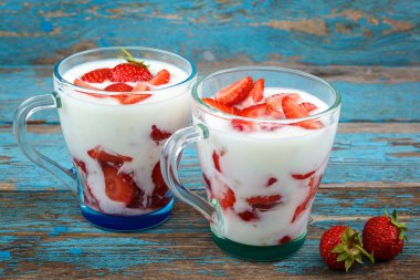 Ahşap arka plan üzerinde bir kasede ekşi kremalı taze çilek.