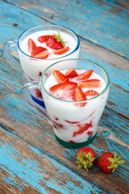 Ahşap arka plan üzerinde bir kasede ekşi kremalı taze çilek.