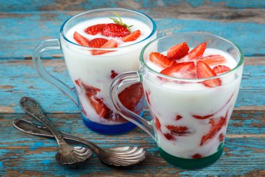 Ahşap arka plan üzerinde bir kasede ekşi kremalı taze çilek.