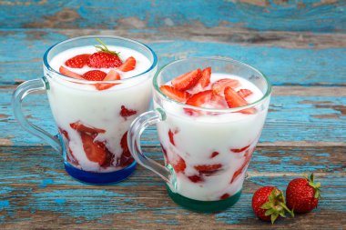 Ahşap arka plan üzerinde bir kasede ekşi kremalı taze çilek.