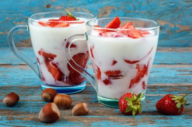 Ahşap arka plan üzerinde bir kasede ekşi kremalı taze çilek.