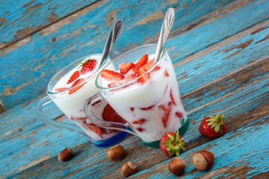 Ahşap arka plan üzerinde bir kasede ekşi kremalı taze çilek.