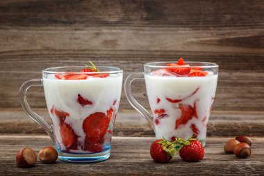 Ahşap arka plan üzerinde bir kasede ekşi kremalı taze çilek.